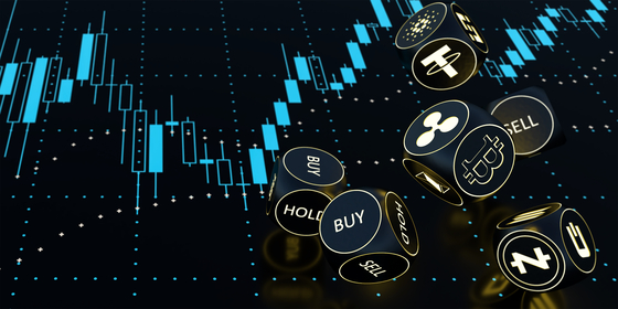 Neon dice show crypto symbols against a candlestick chart screen. [SHUTTERSTOCK]