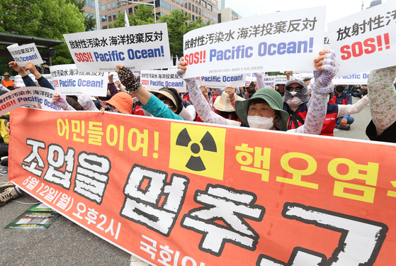 Local fishermen and activists rally against the planned release of the Fukushima Daiichi Nuclear Power Plant's treated radioactive water near the National Assembly building in western Seoul on Thursday. [YONHAP] 