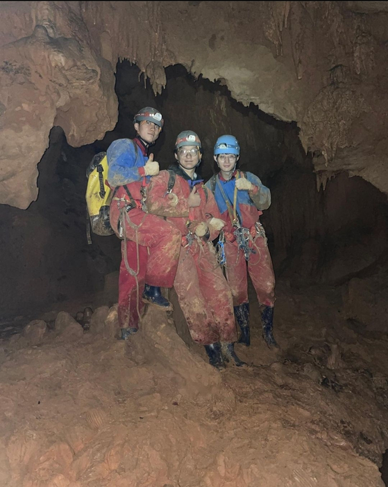 Three members of the Cave Exploration Research Society stop mid-exploration for a photo. [SCREEN CAPTURE]