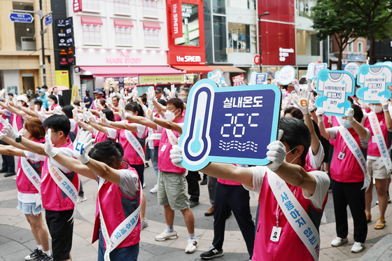 Officials from the city government of Seoul and the Ministry of Trade, Industry and Energy participate in an outdoor campaign to save energy in the streets of Myeong-dong, central Seoul, on Tuesday. [YONHAP]