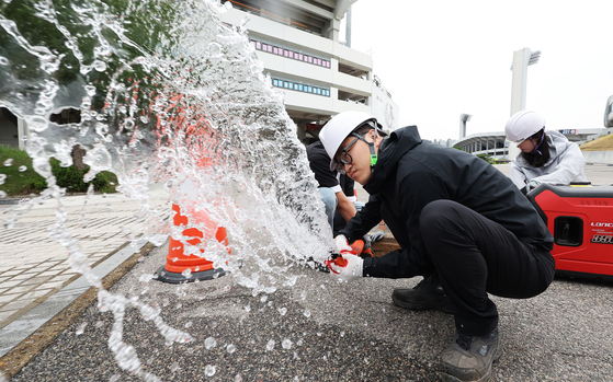 Suwon Urban Development Corp. employees test the water pump system at Suwon Sports Complex in Gyeonggi on Tuesday ahead of the rainy season. While there was some drizzle across the country on Tuesday, heavy rain accompanied by lightning and thunder is expected on Wednesday. Last year the greater Seoul area suffered flood damage especially after drains were clogged. [YONHAP]