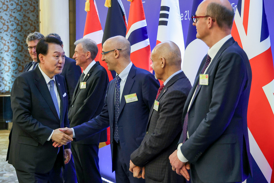 Korean President Yoon Suk Yeol shakes hands with business executives who participated in the event where six European companies pledged a near $1 billion investment to Korea at a hotel in Paris on Wednesday. [YONHAP]