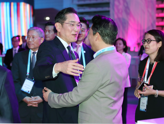Samsung Electronics Executive Chairman Lee Jae-yong, left, hugs Korean singer Psy at Korea's World Expo reception event in Paris Wednesday. [YONHAP]