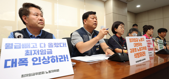 Labor representatives of the Minimum Wage Commission (MWC) announce their minimum wage demand for next year during a press conference held at the government complex in Sejong on Thursday. The labor representatives have demanded next year's minimum wage be set at 12,210 won ($9.44) per hour, up 26.9 percent from this year's 9,620 won. The MWC is a trilateral committee composed of representatives from labor, management and the public that announces new minimum wages by Aug. 5 every year. Management representatives have yet to announce their wage demands. [YONHAP]