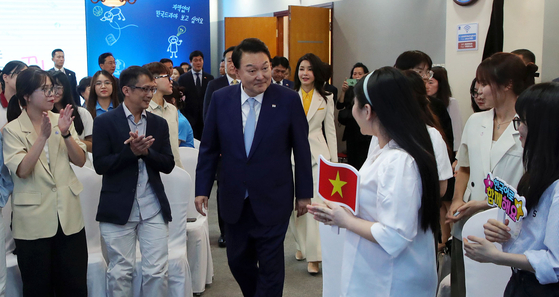 President Yoon Suk Yeol, center, and first lady Kim Keon-hee meet with Vietnamese students at an event promoting Korean language at Vietnam National University in Hanoi Thursday as he kicked off a three-day state visit to Vietnam. [JOINT PRESS CORPS]