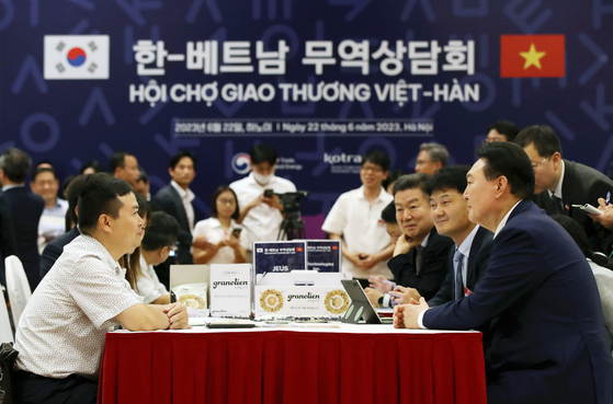 Korean President Yoon Suk Yeol, right, encourages businesses at a trade consultation booth at the Korea-Vietnam Partnership Fair at a convention center in Hanoi Thursday as he kicked off a three-day state visit to Vietnam. [JOINT PRESS CORPS]