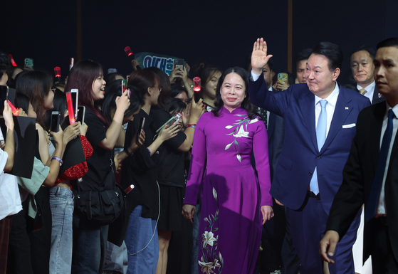 Korean President Yoon Suk Yeol, center, first lady Kim Keon-hee, right, and Vietnamese Vice President Vo Thi Anh Xuan, left, greet fans of K-pop at the Korea-Vietnam Night of Cultural Exchange at the National Convention Center in Hanoi Thursday. [JOINT PRESS CORPS] 