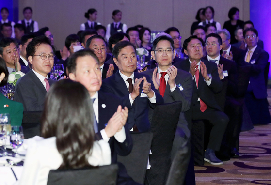 SK Group Chairman Chey Tae-won, Samsung Electronics Executive Chairman Lee Jae-yong, LG Group Chairman Koo Kwang-mo and other leaders of Korea’s top conglomerates applaud after President Yoon Suk Yeol’s address at a dinner banquet with the business delegation at a hotel in Hanoi on Thursday. [JOINT PRESS CORPS]