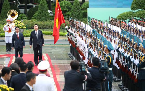 Korean President Yoon Suk Yeol, right, and Vietnamese President Vo Van Thuong observe an honor guard at the welcoming ceremony ahead of their bilateral summit at the presidential palace in Hanoi on Friday. [JOINT PRESS CORPS]
