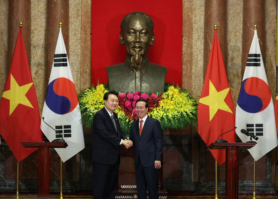 Korean President Yoon Suk Yeol, left, and Vietnamese President Vo Van Thuong shake hands at a joint press briefing after their bilateral summit at the presidential palace in Hanoi on Friday. [JOINT PRESS CORPS]