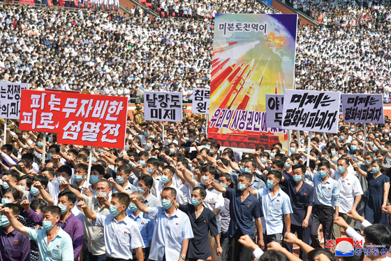 In this photo released by the Korean Central News Agency, North Koreans in Pyongyang participate in a mass anti-U.S. rally on Sunday, which marked the 73rd anniversary of the outbreak of the Korean War. The caption on the large poster reads ″All of the mainland United States is within our range,″ referring to the North's intercontinental ballistic missiles. [YONHAP]