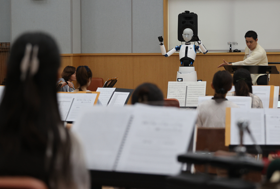 EveR 6, a robot conductor, leads a practice session of the Korean National Orchestra at the National Theater of Korea in central Seoul on Monday. EveR 6 will debut as a conductor at the Korean National Orchestra's recital titled ″Absence″ on Friday, leading two of the five musical compositions by itself and another one with a human conductor. EveR 6 was developed by the Korea Institute of Industrial Technology and will be the world's first robotic orchestra conductor. [YONHAP]