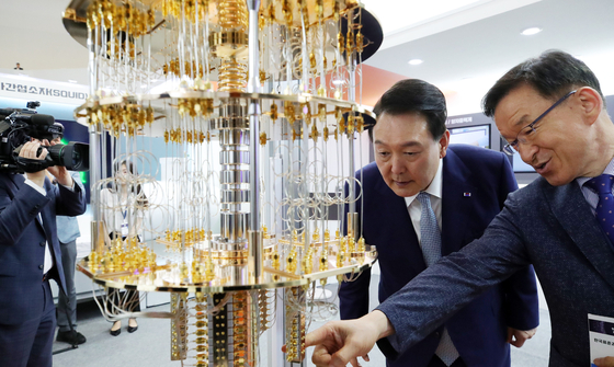 President Yoon Suk Yeol takes a look at a model of a 50-qubit quantum computer on display at the Quantum Korea 2023 exhibition at the Dongdaemun Design Plaza (DDP) in Seoul on Tuesday. Yoon also met with Nobel Prize laureate John Clauser, an experimental physicist who contributed to the foundation of quantum mechanics, and Charles Bennett, a physicist and IBM Fellow at IBM Research. [JOINT PRESS CORPS]