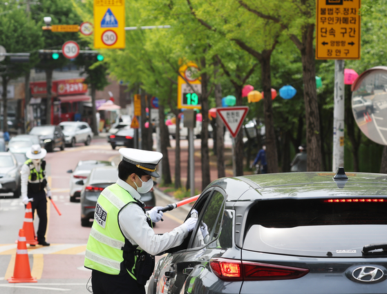 Police test drivers for drunk driving at a street in Suwon in April. [YONHAP]