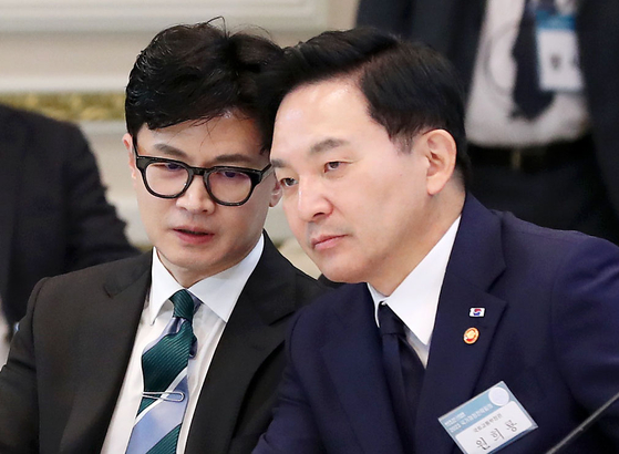 Justice Minister Han Dong-hoon, left, talks with Land Minister Won Hee-ryong during the government meeting on fiscal management held at the Blue House in Seoul on Wednesday. [JOINT PRESS CORPS] 