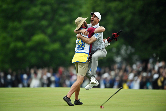 Nick Taylor celebrates with his caddie after making an eagle putt on the fourth playoff hole to win the RBC Canadian Open at Oakdale Golf & Country Club on June 11 in Toronto, Ontario. [GETTY IMAGES]