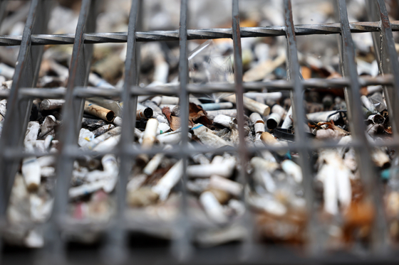 Cigarette butts stacked in a road gutter drain near Gangnam Station in southern Seoul on June 23 [YONHAP]