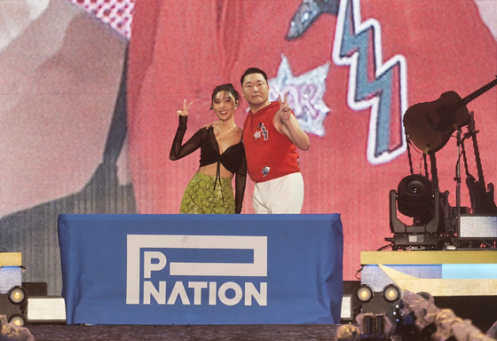 Hwasa and Psy pose after the Mamamoo member signed an exclusive contract with Psy's agency P Nation during the ″Summer Swag″ Seoul concert held Friday at Jamsil Olympic Main Stadium, southern Seoul. [P NATION]