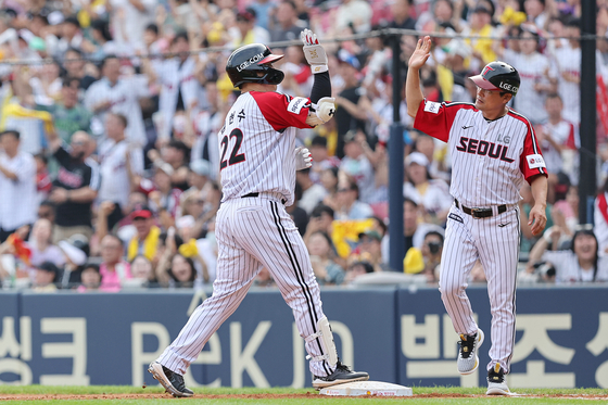 Kim Hyun-soo of the LG Twins high-fives coach Lee Jong-beom after hitting an RBI at the bottom of the third inning of a game against the Kia Tigers at Jamsil Baseball Stadium in southern Seoul on Sunday.  [YONHAP]