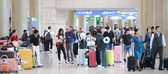 Passengers flock the entrance hall of Incheon International Airport on Sunday. [YONHAP]