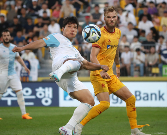 Ulsan Hyundai's Joo Min-kyu, left, shoots during a K League game against Gwangju FC at Gwangju Football Stadium in Gwangju on Sunday. [YONHAP]
