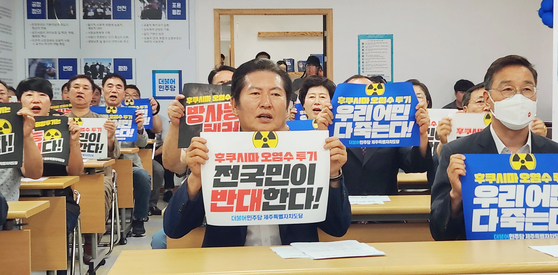 Democratic Party members led by one of its leader Jung Chung-rae, center, protest to the Japanese government's plan to discharge the radioactive treated water from the Fukushima Daiichi Nuclear Power Plant in Jeju on Tuessday. [YONHAP]