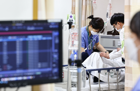 Medical staff members attend to a patient at the emergency ward of Ewha Womans University Seoul Hospital in western Seoul on June 10. [KIM JONG-HO]