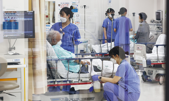 Medical staff members attend to patients at the emergency ward of Ewha Womans University Seoul Hospital in western Seoul on June 10. [KIM JONG-HO]