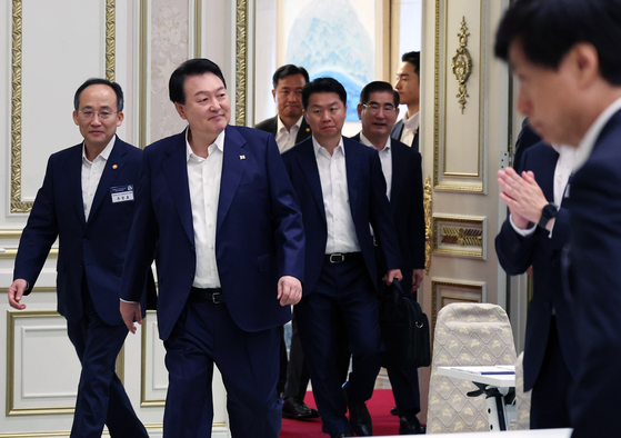 President Yoon Suk Yeol, right, and Finance Minister Choo Kyung-ho enter the Blue House in central Seoul on Tuesday to attend a meeting where the minister briefed the president about economic policy directions. [YONHAP]