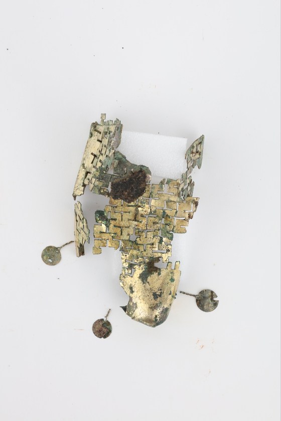 A piece of gilt-bronze shoes that were excavated at the site. The remnants of the shoes were found above the tomb owner's head. [GNIRCH] 