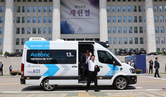 National Assembly Speaker Kim Jin-pyo gets off an autonomous shuttle bus in front of the National Assembly in Yeouido, western Seoul, on Wednesday. Two artificial intelligence technology-incorporated self-driving buses with 10 seats developed by Hyundai Motor will be operating 3.1 kilometers within the National Assembly grounds between 10 a.m. and 4 p.m. taking passengers including visitors from and to the parking lot. The rides will be provided for free.  [YONHAP]