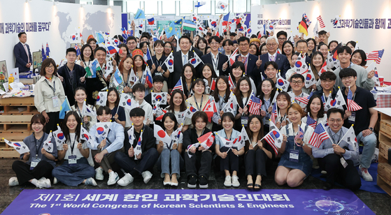 President Yoon Suk Yeol, center, poses for a commemorative photo with young participants from around the world at the inaugural World Congress of Korean Scientists & Engineers at the Korea Institute of Science and Technology Center in Gangnam District, southern Seoul, on Wednesday. The congress was attended by some 500 people, including Korean scientists living abroad. [JOINT PRESS CORPS]