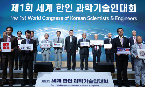 President Yoon Suk Yeol, center, poses for a commemorative photo at the opening ceremony of the inaugural World Congress of Korean Scientists & Engineers at the Korea Institute of Science and Technology Center in Gangnam District, southern Seoul, on Wednesday. The congress was attended by some 500 people, including Korean scientists living abroad. [JOINT PRESS CORPS]