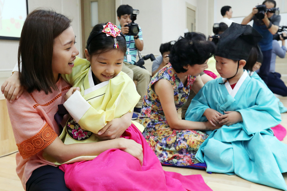 Children thank their teachers with paper carnations for Teacher's Day on May 15 at a daycare center in Gwangju. [YONHAP]