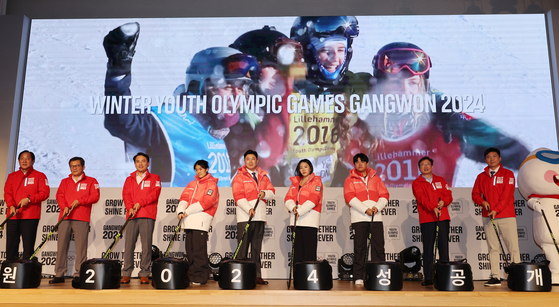 Gangwon Governor Kim Jin-tae, third from left, 2024 Gangwon Youth Olympics Organizing Committee co-heads Jin Jong-oh, fifth from left, and Lee Sang-hwa, sixth from left, and Minister of Culture, Sports and Tourism Park Bo-gyoon, second from right, pose with officials in the uniform for volunteers and staff of the 2024 Gangwon Youth Olympics during an event at Seoul Olympic Parktel in Songpa District, southern Seoul on Thursday. [YONHAP] 