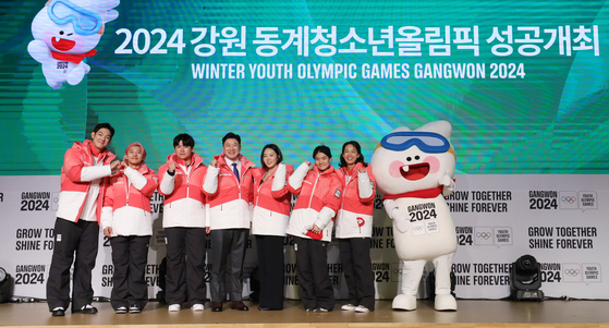 From left: 2024 Gangwon Youth Olympics ambassadors Park Jae-min, Kwak Yoon-gy, Soh Jae-hwan, co-heads of the organizing committee Jin Jong-oh and Lee Sang-hwa, and ambassadors Cho Yun-won and Park Sun-young pose in the uniform for Olympic volunteers and staff during an event at Seoul Olympic Parktel in Songpa District, southern Seoul on Thursday. [NEWS1]