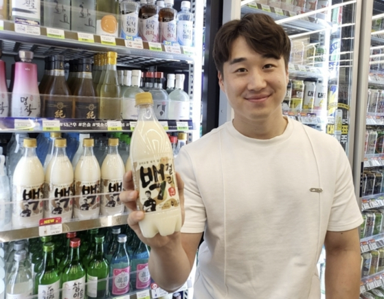 A model holds a bottle of aspartame-free makgeolli (Korean traditional rice wine) that CU, a convenience store franchise run by BGF Retail, introduced on Wednesday. [BGF RETAIL]