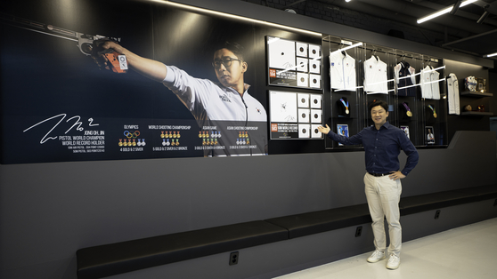 Jin Jong-oh poses for a photo in front of his medals displayed at Jong Oh Jin Shooting Academy in Seongnam, Gyeonggi on June 16. [JOONGANG ILBO] 