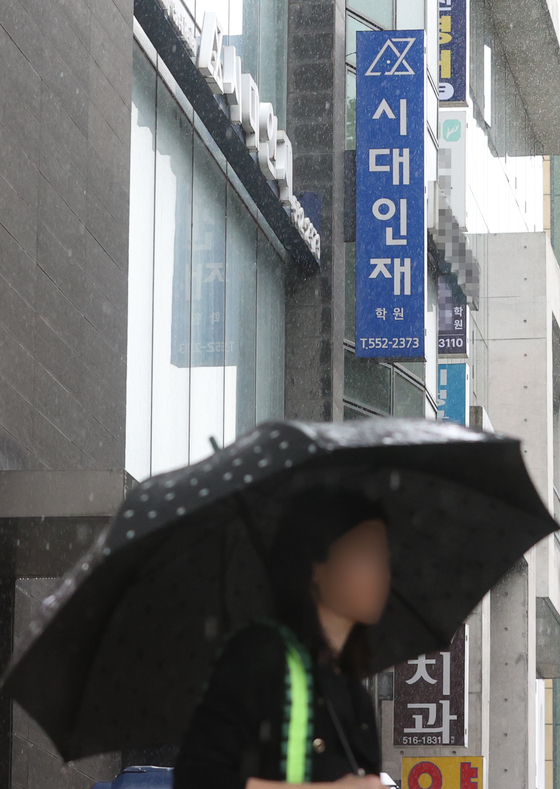 A pedestrian walks past a branch of a private cram school in Gangnam District, southern Seoul, on Tuesday. Major private cram schools are under Fair Trade Commission scrutiny for allegedly posting misleading advertisements and pressure sales tactics for their teaching materials. [YONHAP]