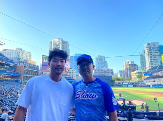 Kevin Sim, left, and his father Shim Chong-soo pose in a photo shared by MLB.com on Monday.  [SCREEN CAPTURE]