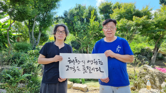 Hangul calligrapher Kang Byung-in poses with Haechang Brewery's CEO Oh Byeong-in with Kang's engraving "The eternal customer of Haechang is quality." [PARK SANG-MOON]