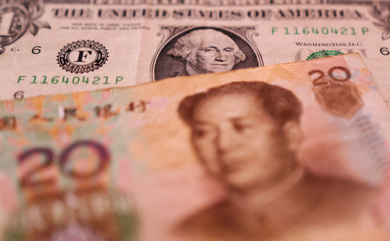U.S. Dollar and Chinese Yuan banknotes are seen [REUTERS]