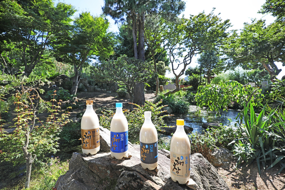 The various types of makgeolli (Korean rice wine) produced by Haechang Brewery, shown under the backdrop of its garden. [PARK SANG-MOON]