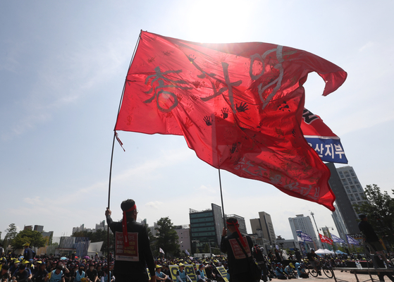 A member of the Korean Confederation of Trade Unions waves a flag during a nationwide metal workers' union strike in Ulsan on Wendesday. [YONHAP]
