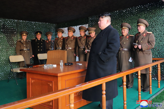Kim Jong-un at an artiliery drill in March. The picture shows a flat smartphone placed on th desk. [KOREAN NEWS AGENCY]