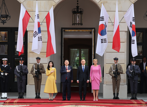 Korean President Yoon Suk Yeol, center left, and Polish President Andrzej Duda, center right, accompanied by their first ladies, Kim Keon-hee and Agata Kornhauser-Duda, take part in an official welcoming ceremony ahead of their bilateral summit in Warsaw, Poland, on Thursday. [JOINT PRESS CORPS] 