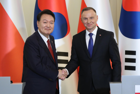 Korean President Yoon Suk Yeol, left, and Polish President Andrzej Duda shake hands at their joint press conference after their bilateral summit at the presidential palace in Warsaw on Thursday. [JOINT PRESS CORPS]