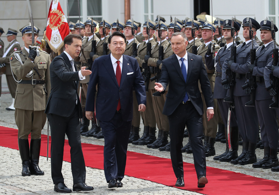 Prezydent Korei Yoon Suk Yeol (w środku) i prezydent Polski Andrzej Duda (po prawej) obserwują gwardię honorową podczas oficjalnej ceremonii powitania przed czwartkowym szczytem dwustronnym w Pałacu Prezydenckim w Warszawie. [JOINT PRESS CORPS] 