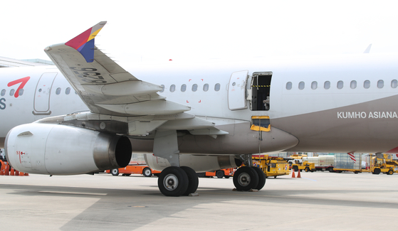 The emergency exit of Asiana Flight 8124 is open while the plane while the plane is on the ground at Daegu International Airport on May 26. A 33-year-old passenger swung open the door just minutes before landing that day. [NEWS1] 