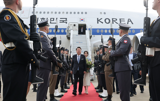 President Yoon Suk Yeol and first lady Kim Keon-hee are greeted by the Polish honor guard upon arrival at the Warsaw Chopin Airport on Wednesday. Yoon's visit to the country comes after he attended the NATO summit on Tuesday and Wednesday in Lithuania. This is the first time in 14 years for a Korean president to visit Poland. [YONHAP] 